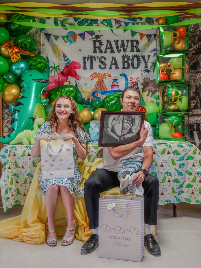 Couple opening gifts at baby shower